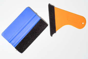 Blue And Orange Plastic Squeegees With Black Felt Edges On White Background