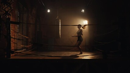 Sport and fitness, athletic woman training in night in boxing ring, jumping rope . Active pastime for stay healthy and slender, lose weight and keep fit, professional sportswoman developing endurance - Powered by Adobe