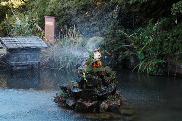 Whimsical Frog Character Fountain in a Lush Garden Pond
