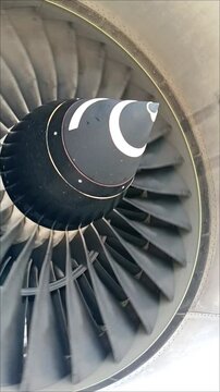 Close-up of aircraft turbofan engine fan blades rotating slowly after engine shutdown