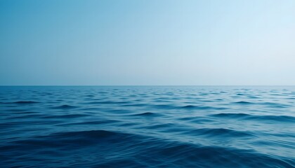 Fototapeta premium Blue aesthetic wallpaper of a calm ocean with gentle waves under a soft blue sky.