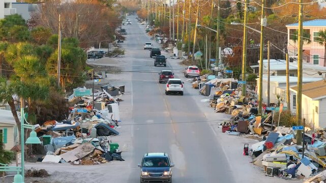 Hurricane Milton aftermath cleanup. Piles of debris and sand on street side on Manasota Key in Florida.