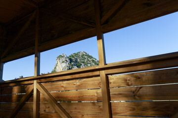 Discovering nature's beauty from a wooden lookout point, enjoying stunning mountain views under a clear blue sky