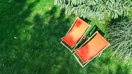 Summer garden with sunbed deckchairs on grass aerial top view, green park trees and place for relax from above