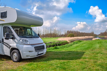 Сamper (rv) in camping with beautiful nature landscape on background, campsite view, family travel in motorhome on holiday vacation trip concept