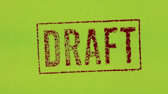 Close-up of a red draft stamp sign with a green background.