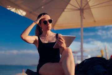 Worried Woman Holding a Tablet at The Beach. Stressed businesswoman working remotely by the sea