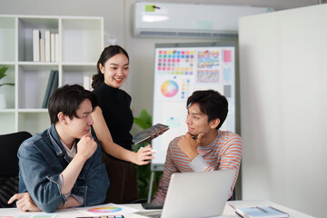 Collaboration and Creativity. Three graphic designers discussing design concepts and brainstorming ideas in a modern workspace.
