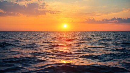 Obraz premium Vibrant sunset reflecting on the tranquil oceanic surface and gentle clouds