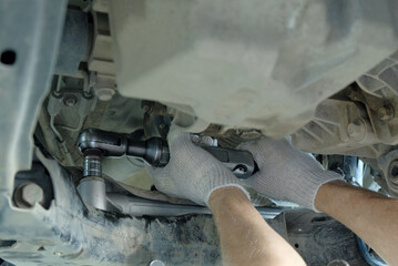 Repair of the steering mechanism of the car in the car service center.An auto mechanic performs the...
