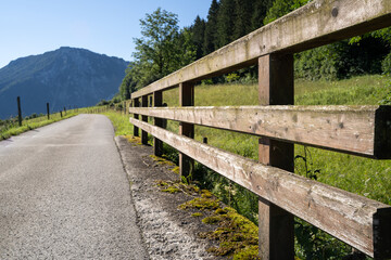 Mountain road with wooden bridge railing in the landscape