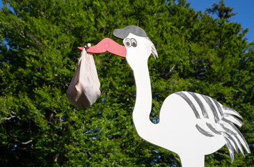 Wooden stork with baby bundle in beak a traditional birth sign