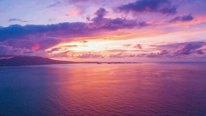 Beautiful sunset over the ocean with a few clouds in the sky