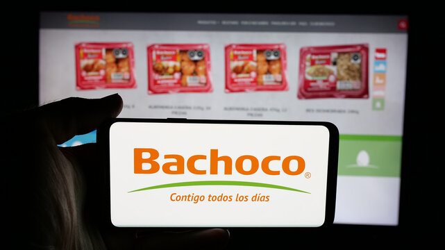 Stuttgart, Germany - 05-15-2025: Person holding cellphone with logo of company Industrias Bachoco S.A. de C.V. on screen in front of webpage. Focus on phone display.
