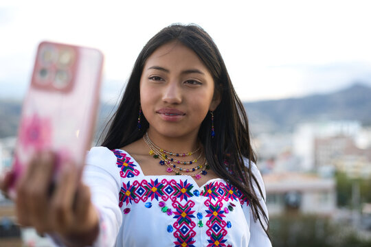 Latin american woman taking selfie wearing traditional clothes