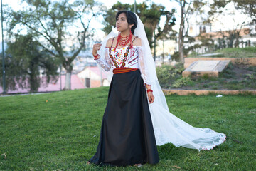 Indigenous bride wearing traditional andean dress and veil in park