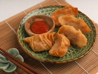 Gyoza or fried dumplings on a plate on white background