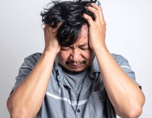 A distressed man sits on a park bench, his head buried in his hands, conveying deep frustration or sadness, surrounded by autumn leaves.