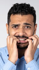 A man with an expressive face, mouth open in surprise or awe, rests his hands thoughtfully on his chin, showcasing deep contemplation or curiosity.