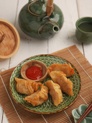 Gyoza or fried dumplings on a plate on white background