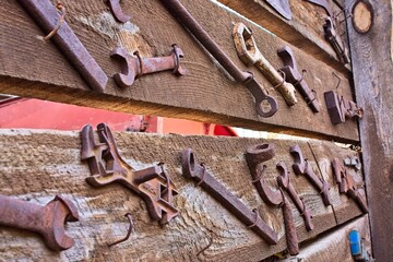 Old, rusty tools on a wooden wall. Jerome, Arizona.