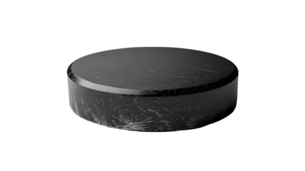 A close up shot of a black hockey puck with visible scratches on a dark background in a studio setting isolated on transparent background