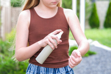 A teenager applies insect spray on his hand. The concept of prevention from mosquito bite.