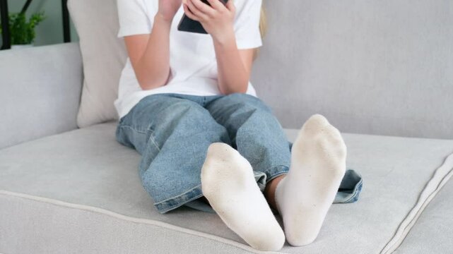 The child has dirty socks. The girl uses a mobile phone