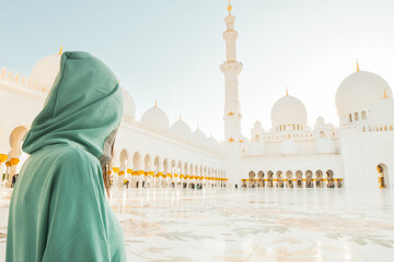 Abu Dhabi, UAE - april 25th, 2025: woman traveler wear stylish abaya sightseeing Sheikh Zayed Grand Mosque in Abu Dhabi on beautiful sunset. Fusion of Islamic and Modern Architecture