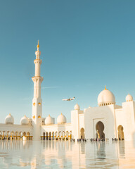 Luxury private jet landing above the iconic Sheikh Zayed Grand Mosque in Abu Dhabi. Modern aviation and Islamic architecture highlights opulence, travel, and cultural landmarks in the UAE capita