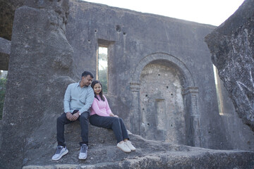 A joyful young couple sharing a loving moment on a peaceful street surrounded by greenery