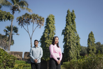 A joyful young couple sharing a loving moment on a peaceful street surrounded by greenery