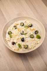 Delicious oatmeal topped with nuts and grapes