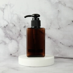 Minimalist amber pump bottle on white podium
