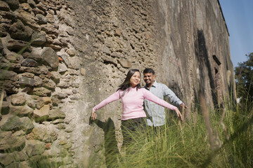 A joyful young couple sharing a loving moment on a peaceful street surrounded by greenery