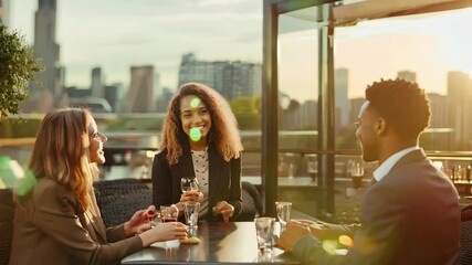 Corporate professionals engage in lively discussions over drinks at a rooftop restaurant during sunset in an urban city skyline