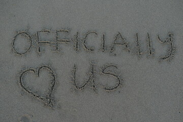 Officially Us Message on Volcanic Sand with Heart Symbol