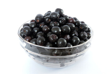 Fresh ripe aronia berries decorated in a glass bowl, white background
