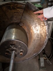 A person is pointing at a piece of machinery with a hand