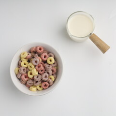 Colorful cereal served with milk on white background 