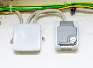 Secured wall socket with lock and adjacent junction box on basement wall