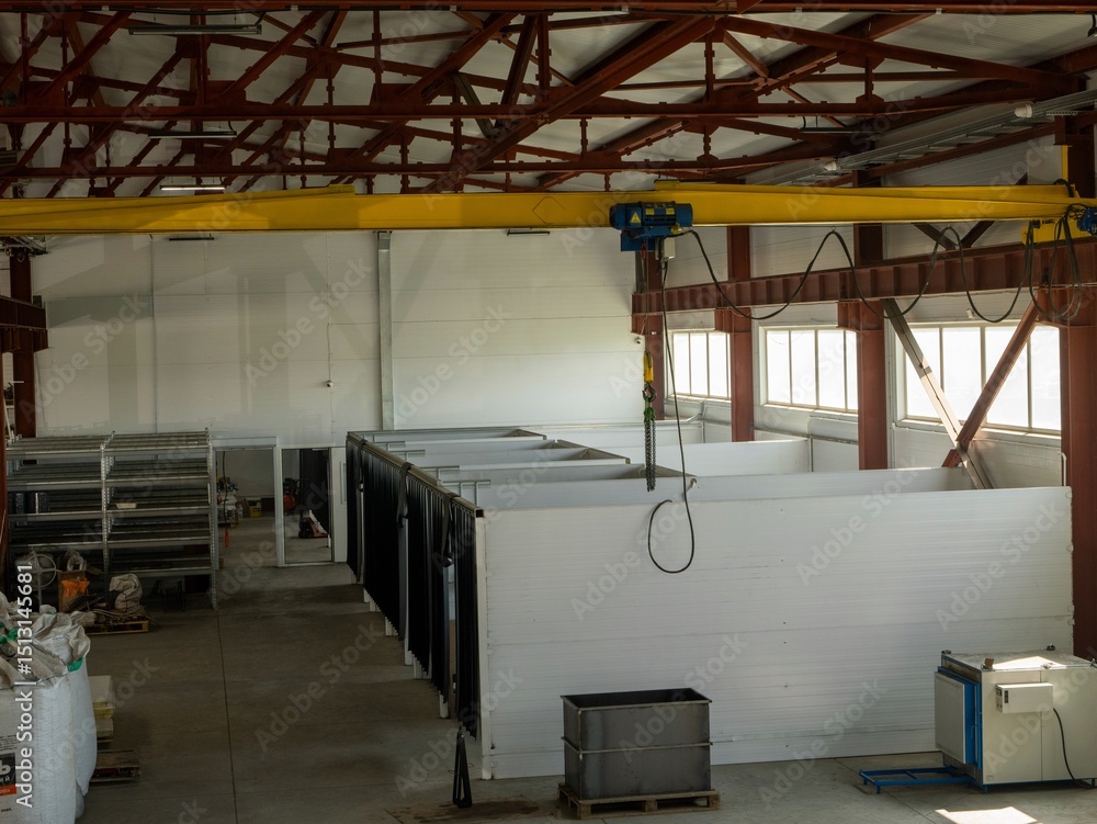 Poster a large industrial building with a crane hanging from the ceiling