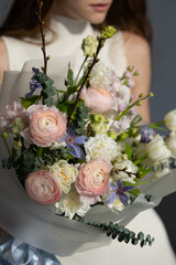 Beautiful floral bouquet held by young caucasian female in soft light