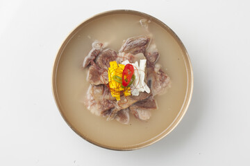  A dish of rice cooked in a soup made with beef head meat, bones, radish, and other vegetables.   
