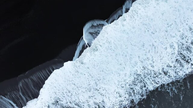 Abstract pattern in nature, Aerial view of black sand volcanic beach with crashing waves