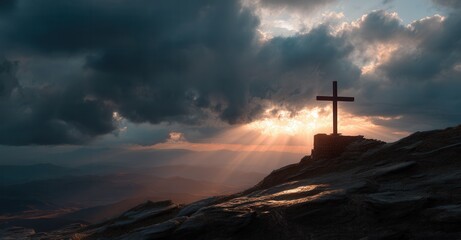 Silhouette of a cross atop a rocky mountain, backlit by golden sunlight breaking through dark clouds in a majestic, spiritual landscape.