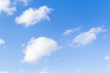 White airy beautiful clouds in a bright blue sky. Clear sunny weather. The concept of environmental safety and cleanliness..