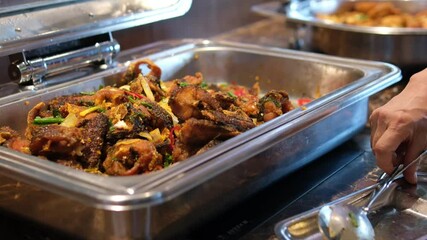 meatballs in the buffet Deep fried foods such as Chicken Drumsticks, Meatballs and Torfu in stainless steel trays, being kept warm inside a glass display counter cabinet. In a local buffet restaurant.