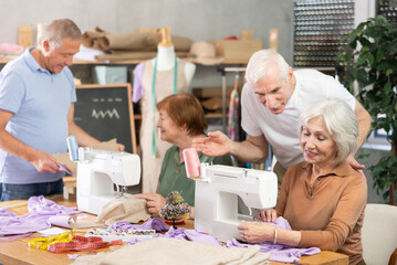 Elderly participants in educational coterie study sewing. Some people communicate and discuss...