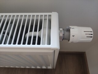 White radiator providing warmth and comfort in modern apartment set to maximum five level